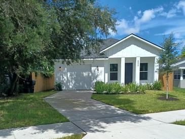 White farmhouse exterior with a gray roof, landscaping, and driveway at 6534 Wayne St, St Petersburg, FL 33702