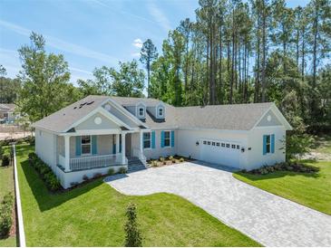 Charming single-story home with a large driveway, craftsman details and manicured lawn at 4780 Majestic Hills Loop, Brooksville, FL 34601