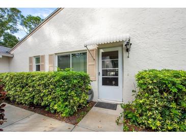 Condo exterior showcasing a walkway, hedges and white walls at 3348 38Th S Way # C, St Petersburg, FL 33711