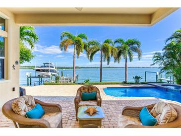 Relaxing patio overlooking a pool and waterfront with boat dock at 17371 Kennedy Dr, North Redington Beach, FL 33708