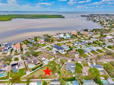 Aerial view of waterfront property with surrounding houses and boat docks at 6070 Denver Ne St, St Petersburg, FL 33703