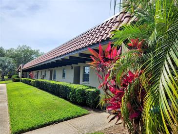 Building exterior showcasing Spanish-style architecture and landscaping at 1701 Pinehurst Rd # 26E, Dunedin, FL 34698