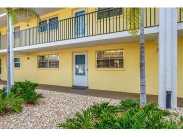 Exterior view of a building with a walkway and landscaping at 821 Deleon Ct # 103, Dunedin, FL 34698