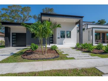Modern home with gray and white exterior, landscaping, and walkway at 4511 24Th S Ave, St Petersburg, FL 33711
