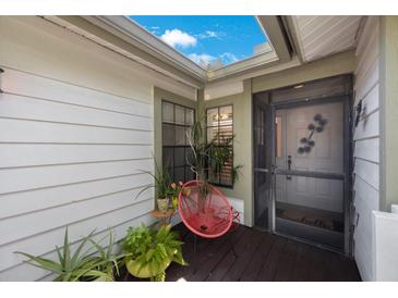Inviting front entry with red chair and plants at 842 Amelia Ne Ct, St Petersburg, FL 33702
