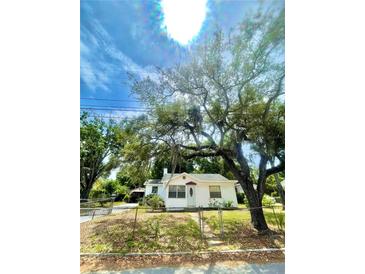 White house with mature trees and fence at 37 W Martin Luther King Jr Dr, Tarpon Springs, FL 34689