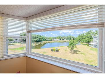 Bright room featuring large windows offering scenic views of the community lake at 2228 Swedish Dr # 42, Clearwater, FL 33763
