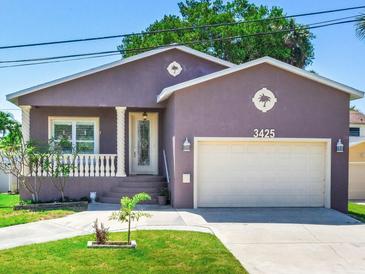 Purple house with a two-car garage and manicured lawn at 3425 Overlook Ne Dr, St Petersburg, FL 33703