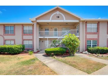 Two-story condo building with brick and light-colored exterior and lush landscaping at 6428 Gloria Dr # 15, New Port Richey, FL 34653