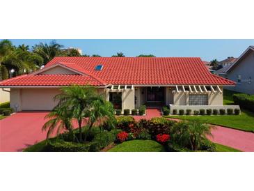 Single-story home with red tile roof, landscaping, and a paved driveway at 4981 61St S Ave, St Petersburg, FL 33715