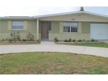 House exterior, showcasing a single-story home with a driveway and landscaping at 4102 Darlington Rd, Holiday, FL 34691