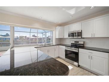 Modern kitchen with stainless steel appliances and granite countertops at 910 Spindle Palm Way, Apollo Beach, FL 33572