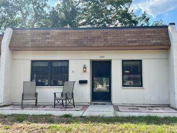White house with black framed windows and patio chairs at 1280 Mission Cir # 45C, Clearwater, FL 33759