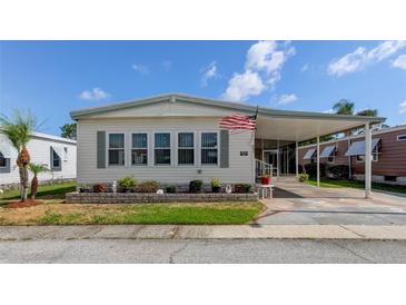 Mobile home with covered carport and landscaped yard at 402 Blue Marlin Dr, Oldsmar, FL 34677
