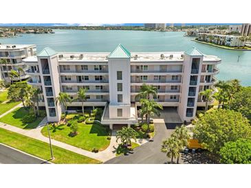 Aerial view of waterfront condo building with lush landscaping at 8001 Sailboat Key S Blvd # 204, St Pete Beach, FL 33707
