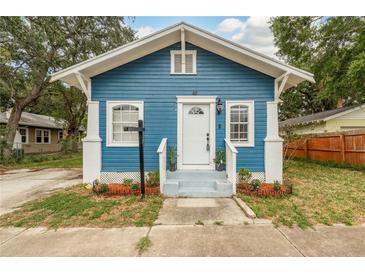 Charming blue house features a well-manicured front yard, white trim and a welcoming front porch at 49 W Boyer St, Tarpon Springs, FL 34689