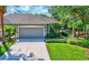 One-story home with gray garage door and lush landscaping at 10426 48Th E Ct, Parrish, FL 34219