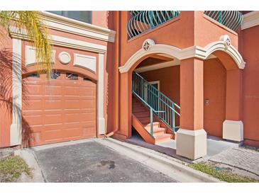 Exterior view of a condo building with a garage and stairs at 2746 Via Tivoli # 132B, Clearwater, FL 33764