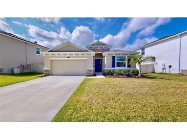 Charming one-story house with two-car garage and landscaped lawn at 30964 Penny Surf Loop, Wesley Chapel, FL 33545