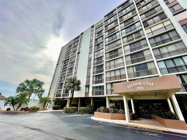 Dolphin Cove building exterior, with parking and landscaping at 255 Dolphin Pt # 809, Clearwater, FL 33767