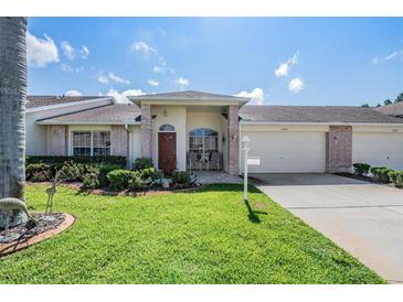 Brick front home with two-car garage and well-manicured lawn at 1044 Blyth Hill Ct, Trinity, FL 34655