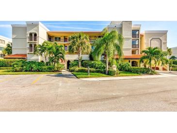 Two-story condo building with lush landscaping and ample parking at 7532 Bayshore Dr # 205, Treasure Island, FL 33706