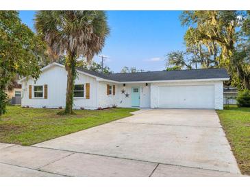 Charming single-story home with a lush lawn, a large driveway, and a welcoming light blue front door at 508 Brooker Rd, Brandon, FL 33511