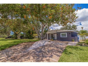 Gray house with white trim, landscaping, and a long driveway at 4134 Huntington Ne St, St Petersburg, FL 33703