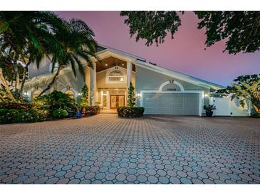 Two-story home with a large driveway and mature landscaping at 10109 Tarpon Dr, Treasure Island, FL 33706