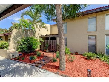 Attractive Florida condo with palm trees, brick pathway, and well-manicured landscaping at 7200 Ulmerton Rd # F2, Largo, FL 33771