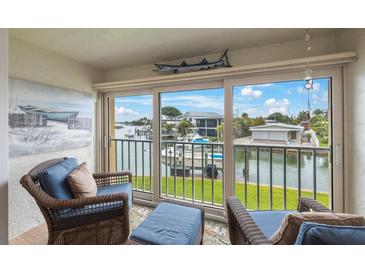 Bright sunroom with wicker furniture and stunning water views at 175 116Th Ave # 102, Treasure Island, FL 33706