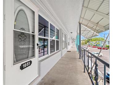 Exterior of condo with unit number 1051, a walkway, and a parking lot at 4071 55Th N Way # 1051, Kenneth City, FL 33709