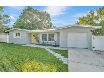 Charming ranch home with a yellow door and well-maintained lawn at 10617 N 27Th St, Tampa, FL 33612