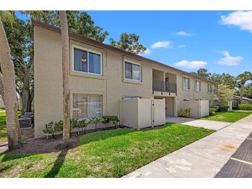 Tan condo building with grassy areas and walkways at 4215 E Bay Dr # 1506E, Clearwater, FL 33764