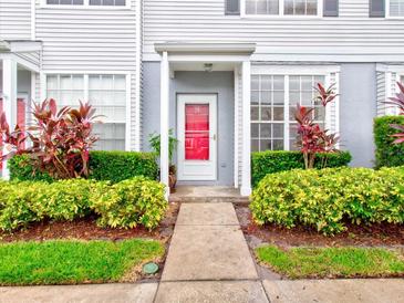Townhouse with red front door, landscaping, and walkway at 2745 Enterprise E Rd # 24, Clearwater, FL 33759
