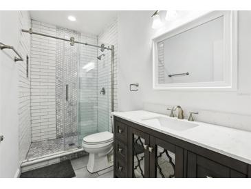 Updated bathroom featuring a glass shower door, subway tile, and modern vanity with white marble countertop at 2272 Chianti Pl # 4-0048, Palm Harbor, FL 34683