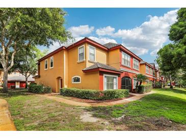 Charming two-story townhome with colorful stucco exterior and well-manicured landscaping, creating inviting curb appeal at 2272 Chianti Pl # 4-0048, Palm Harbor, FL 34683