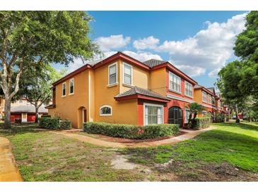 Charming two-story condo with a red tiled roof, complemented by lush landscaping and colorful accents at 2272 Chianti Pl # 4-0048, Palm Harbor, FL 34683