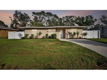 Tan single story home with white fence and landscaping at 831 Searcy Ave, Sarasota, FL 34237