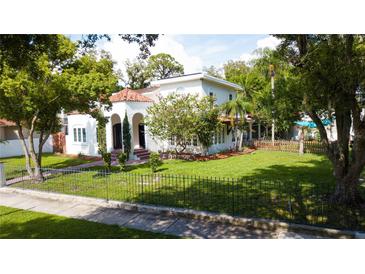 Two-story house with a white stucco exterior, red brick walkway, and a lush lawn at 5501 Bates St, Seminole, FL 33772