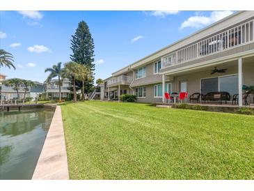 Spacious backyard with lush green grass, overlooking a canal at 400 Larboard Way # 106, Clearwater Beach, FL 33767