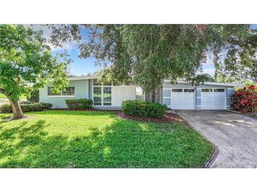 Charming single-story home with a well-manicured lawn and a two-car garage at 161 Overbrook W St, Largo, FL 33770