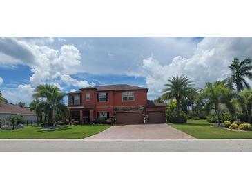 Two-story house exterior with brick paver driveway and lush landscaping at 7607 55Th E St, Ellenton, FL 34222