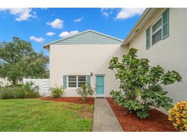 Charming condo building with a teal door and landscaping at 3247 38Th S Way # C, St Petersburg, FL 33711