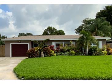 Ranch style home with landscaped lawn and red garage door at 6387 17Th N Ter, St Petersburg, FL 33710