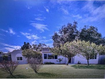 Ranch-style home with a spacious front yard and mature trees at 910 Robinson N Dr, St Petersburg, FL 33710