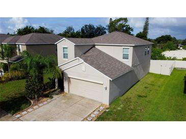 Two-story house with attached garage and landscaped lawn at 105 Cascade Bend Dr, Ruskin, FL 33570
