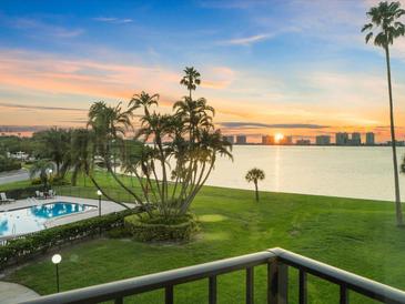 Stunning sunset view over the water with pool in foreground at 100 Oakmont Ln # 301, Belleair, FL 33756