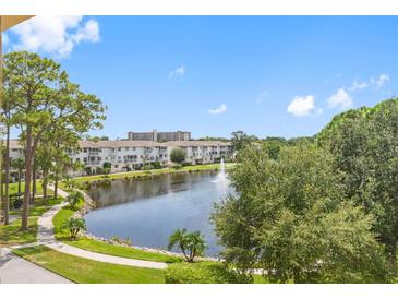 Tranquil pond and walking path with lush landscaping in a resort-like community at 5775 Park N St # 411, St Petersburg, FL 33709