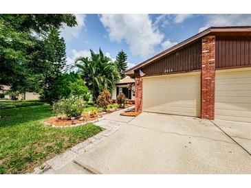 Brick home with a two-car garage and well-maintained landscaping at 2014 Montego Ct, Oldsmar, FL 34677